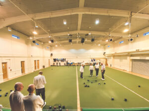 Members playing indoor bowls at Istead Rise Community Centre, with the indoor carpet green and bright overhead lighting